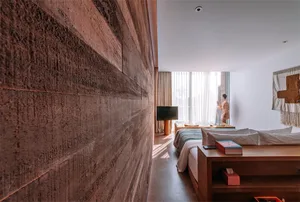 Modern bedroom featuring a minimalist design with a wooden wall and a large bed.
