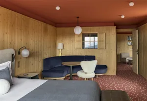 Modern bedroom featuring wooden walls and furnishings.