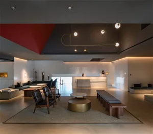 Interior design of a modern hotel lobby featuring concrete, leather, and wooden furniture.