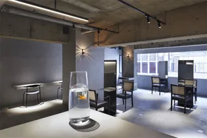 Interior design of a modern restaurant bar with concrete and glass materials.