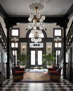 Classical-style lobby featuring marble columns, glass chandelier, and carpet flooring.
