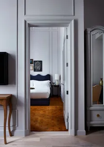 A modern bedroom with white walls, a brown carpet, and a black headboard.