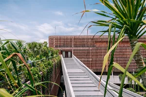 A modern building with stairs leading to the entrance, featuring wood construction.