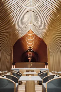 A modern minimalist restaurant interior featuring wooden architectural elements and geometric lighting.