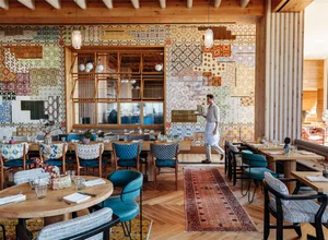 Modern restaurant interior with patterned tiles and wooden elements.