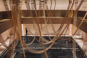 A modern lobby with a sophisticated design featuring marble and wooden elements.