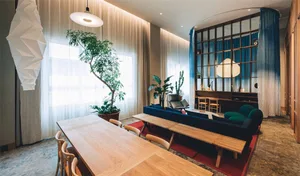 A minimalist living room featuring wooden furniture and glass partitions.