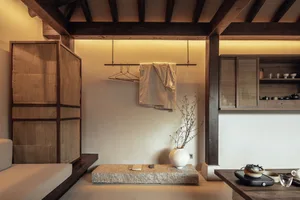 極簡風格客廳，搭配石材地板、木質天花板橫樑，以及懸掛式衣帽架。