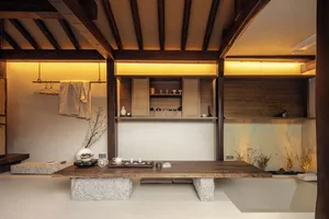 A modern tea room featuring wooden shelves and a stone floor.
