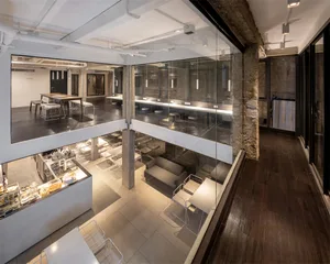 An overhead view of an industrial-style restaurant with concrete walls and floors, featuring seating areas and a bar.