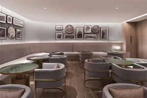 Modern coffee shop interior with fabric seating, wooden flooring, and framed art on the walls