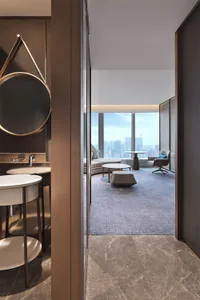 A modern living room featuring marble surfaces, glass elements, and leather furniture.
