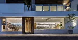 Modern retail storefront with a wooden entrance, concrete storefront, and glass window