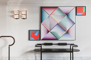 A modern lobby space featuring a wall installation with a multicolor geometric abstract pattern.