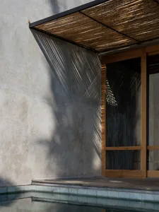 Minimalist architecture featuring concrete walls and a wooden deck.