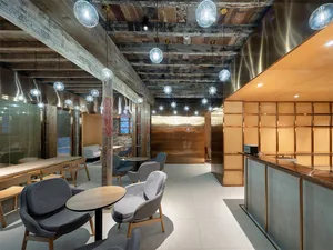 寬敞的工業風咖啡廳室內，展現金屬、木質與混凝土元素。