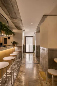 Industrial-style restaurant with concrete walls and wooden seating.