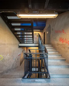 Industrial-style staircase with concrete steps and black metal railing.