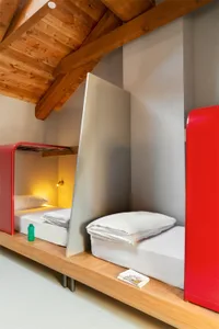 A modern bedroom featuring bunk beds with grey concrete walls.