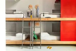 A modern bedroom featuring wooden bunk beds with red accents.