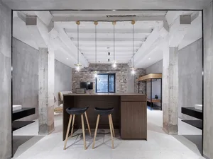 A modern coffee shop bar with concrete, brick, and walnut materials