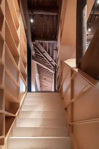 A modern interior with concrete stairs leading to a wooden ceiling
