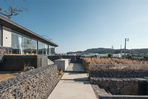 A modern residential exterior with concrete and stone materials.