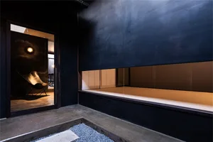 A modern residential interior featuring minimalist design with concrete flooring and walls.