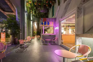 A modern restaurant interior with concrete elements and green plants.