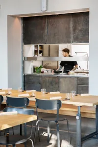工業風餐廳廚房，設有金屬操作台與開放式格局。