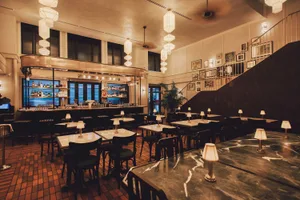 Marble tables and chairs in an industrial-themed restaurant interior