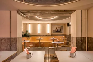 Modern restaurant interior with concrete walls and minimalist design elements.