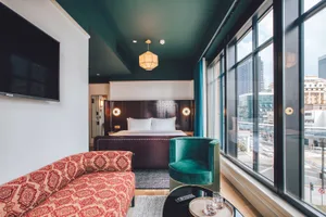 Modern bedroom with fabric furniture, city view, and mixed materials.