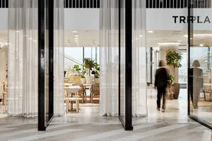 A modern cafe interior with white curtains and contemporary decor.