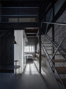 A modern industrial loft space with concrete floors, metal beams, and glass elements.