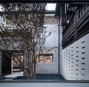 Modern interior design featuring wooden furniture, concrete flooring, and glass walls.