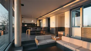 Modern living room featuring a concrete floor, glass windows, and neutral fabric furnishings.
