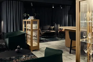 A modern living room featuring dark materials such as glass and wood.