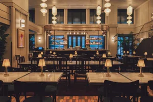 Modern restaurant interior with polished marble tables and concrete accents