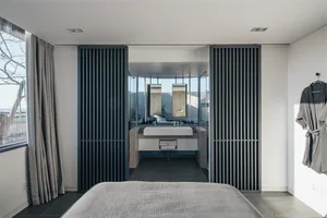 A modern bedroom featuring concrete and glass materials.