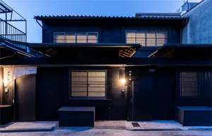 A modern architecture building with wooden exterior features illuminated at night.