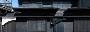 A modern building facade with metal panels and a blurred background.