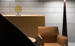 A minimalist office lounge featuring wood furniture and leather accents.