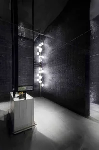 Modern lobby with textured black tiles and concrete elements