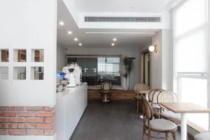 Modern restaurant interior with white walls and a brick-clad coffee counter