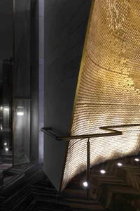 Staircase with a metal hexagon pattern illuminated by lights overhead