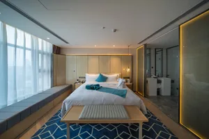 A modern bedroom featuring wooden furniture and a blue patterned rug.
