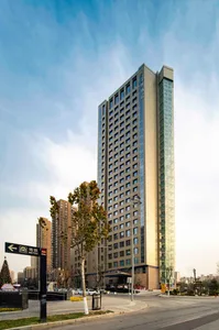 Modern hotel building with glass and concrete exterior.