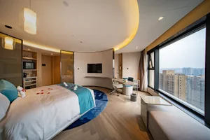 Modern hotel room with wooden floor, glass window, and fabric bedding.