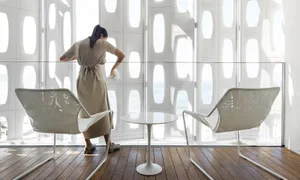 Modern interior space with transparent glass walls showcasing a coastal view.